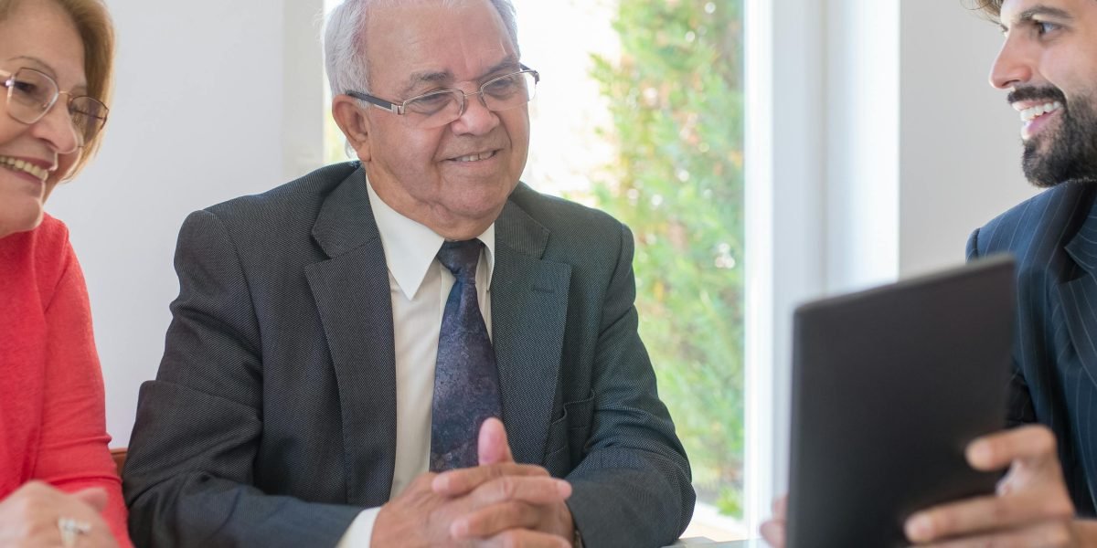 A real estate advisor confidently discussing market strategies with clients in an office setting.