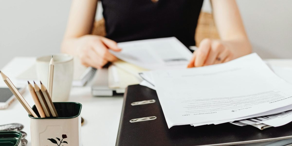 A person carefully comparing different broker fee proposals and service offerings.
