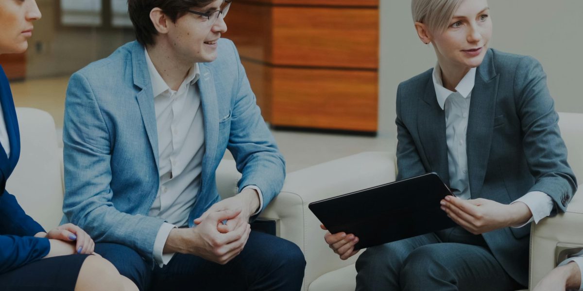 A professional real estate broker consulting with clients in an office setting, discussing property options.