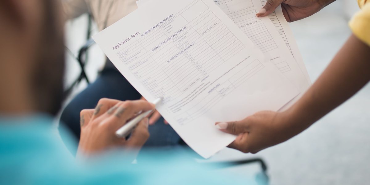 A diverse group of people collaborating around a table with documents, representing expats getting assistance to secure property.
