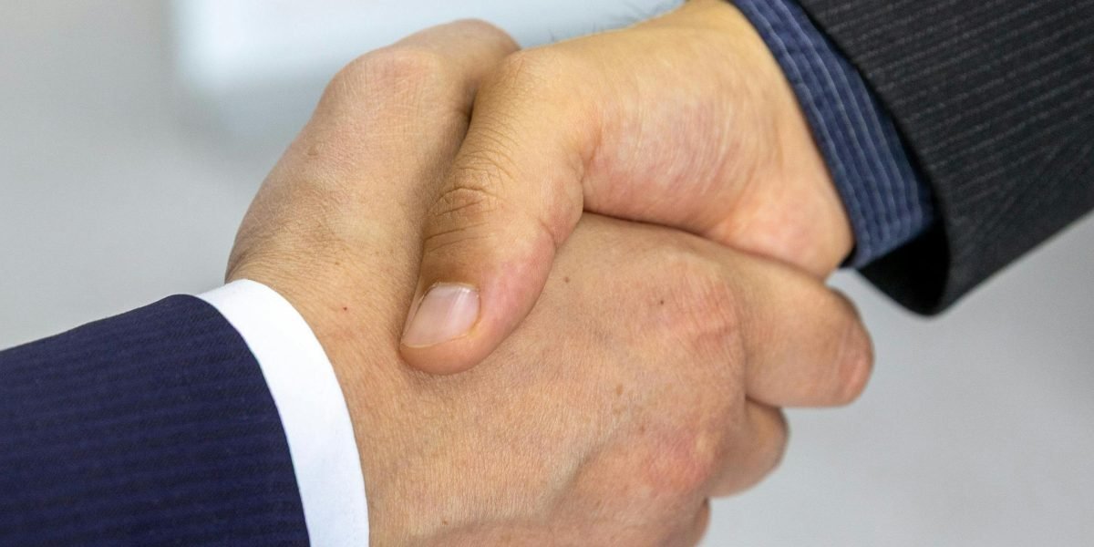 A handshake between two professionals, symbolizing trust and a successful agreement with a chosen and trustworthy agent.