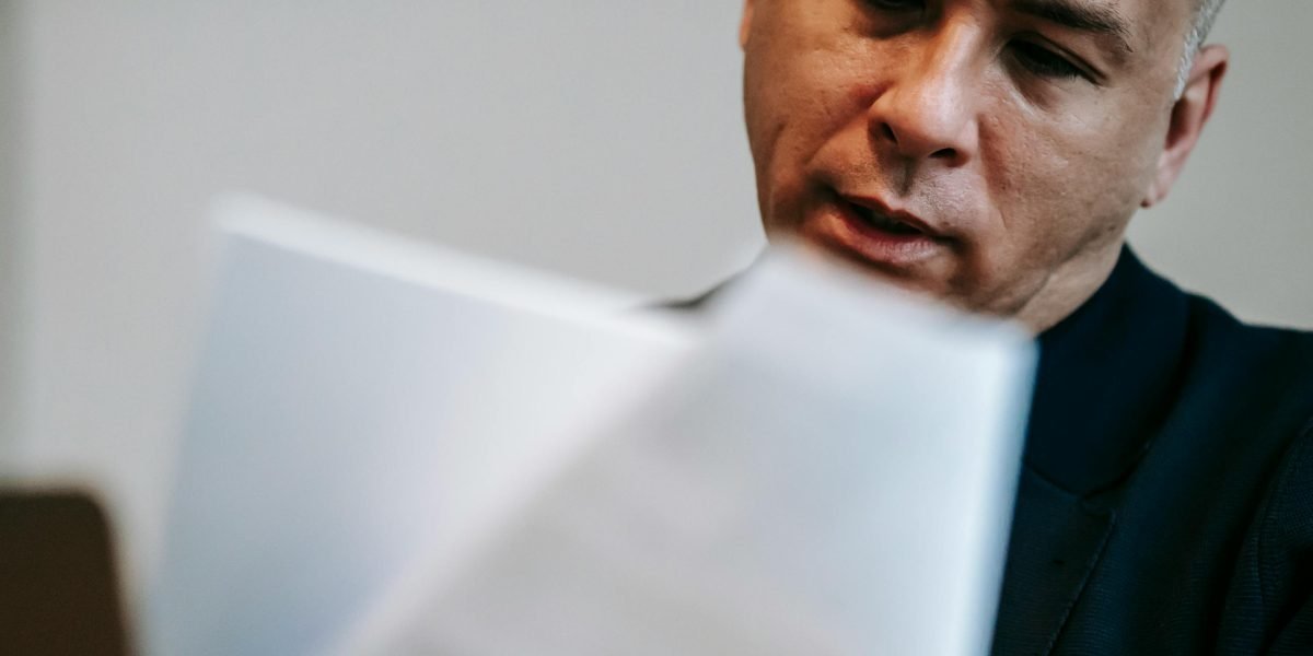 A person carefully reviewing legal documents, emphasizing the importance of understanding contract terms.